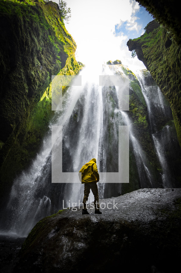 man standing in front of a waterfall 