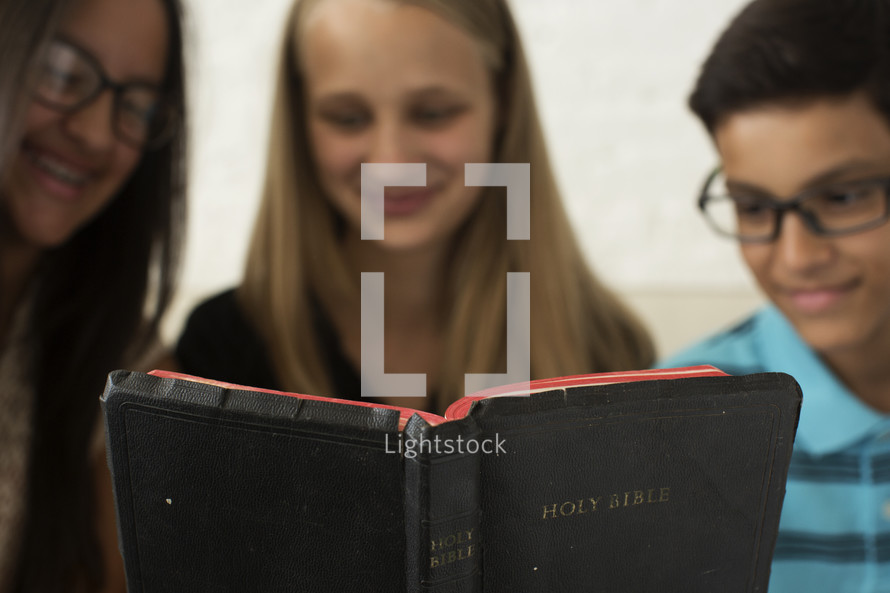kids reading a Bible together 