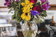 a vase of colourful flowers on desk