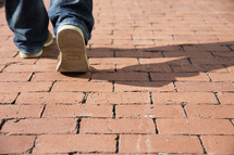 feet walking on a brick patio 