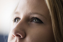 Closeup of a woman's face with eyes looking up and in thought.