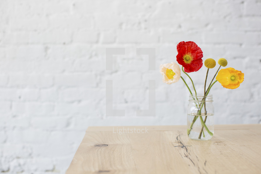 poppies in a vase on a table 