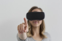 A woman wearing VR glasses and pointing 