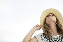 woman in a straw hat looking up to God 