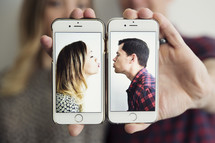 kissing couple on cellphones
