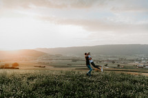 couple embracing on a hill at sunset 
