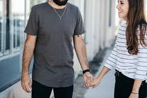 couple on a sidewalk holding hands 