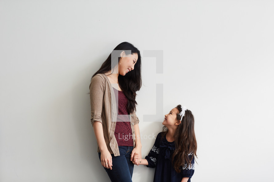 a mother and daughter holding hands in studio