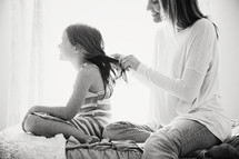 a mother braiding her daughter's hair 