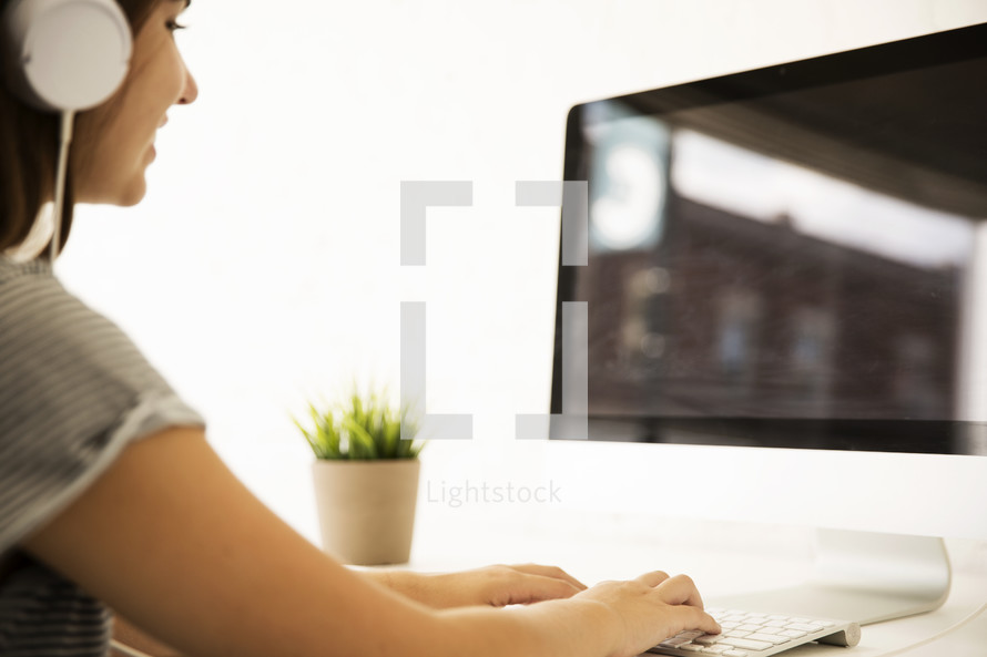 woman wearing headphones working at a computer 