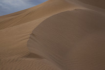 The windswept ridge of a sand dune in the desert