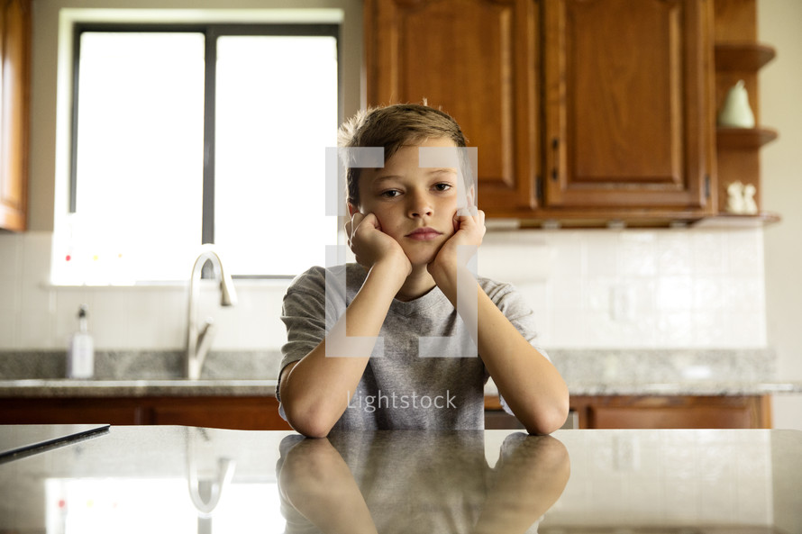 a pouting little boy in a kitchen 