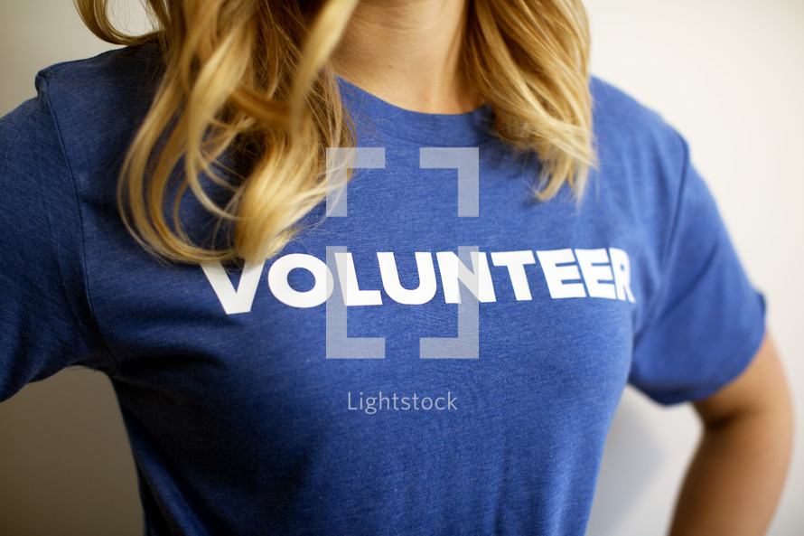 A woman wearing a blue t-shirt reading, "volunteer."