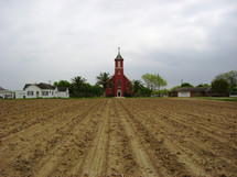 red church and plowed field 