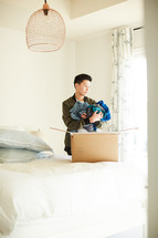 a teen boy packing a moving box 