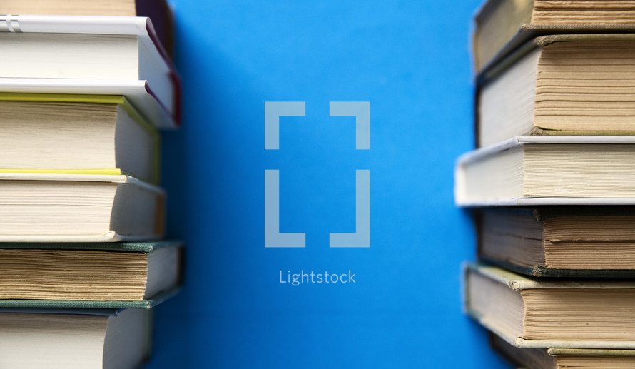 stacked books on blue background.