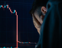 Frustrated depressed man holding head in hands shocked when global stock market going down.
