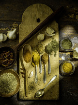 Spoons with spices on wooden table