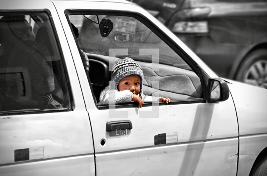 a toddler looking out a car window 