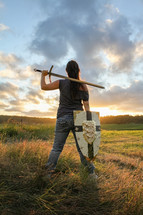 Warrior woman spies the land, resting a double-handle sword and a shield by her side. 