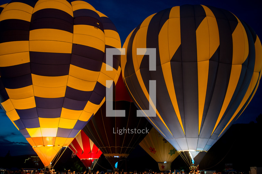 Hot air balloons lit up at a festival.