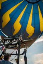 A man flying inside a hot air balloon.