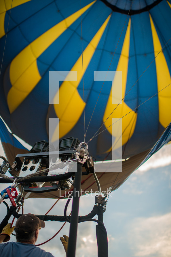 A man flying inside a hot air balloon.