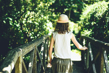 a little girl crossing a footbridge 