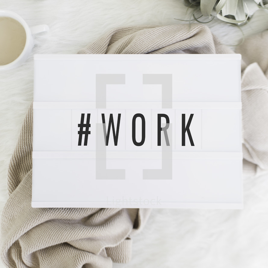 # work sign and blanket, coffee mug, and reading glasses 