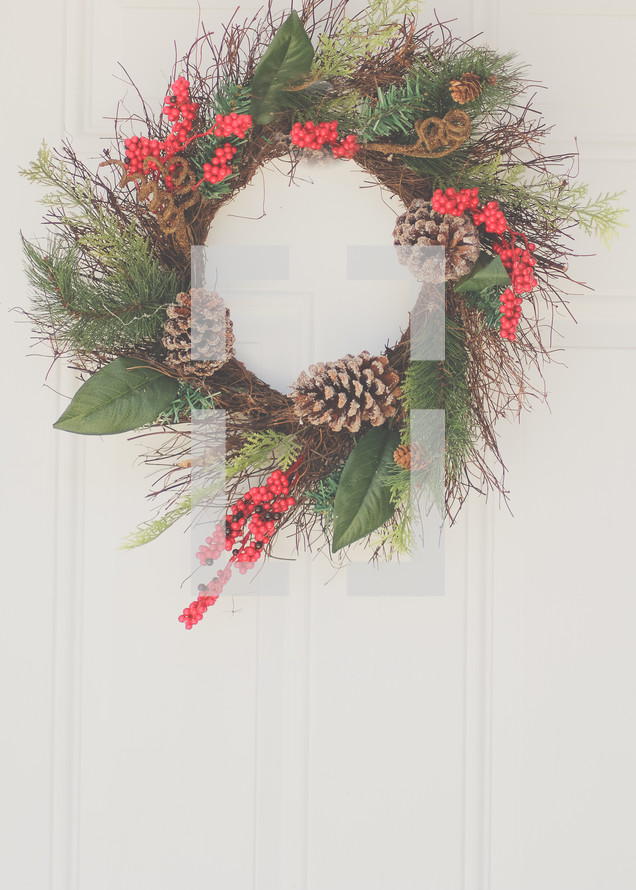 a Christmas wreath hanging on a door 