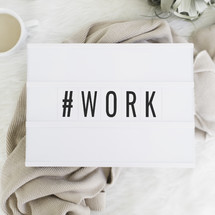 # work sign and blanket, coffee mug, and reading glasses 