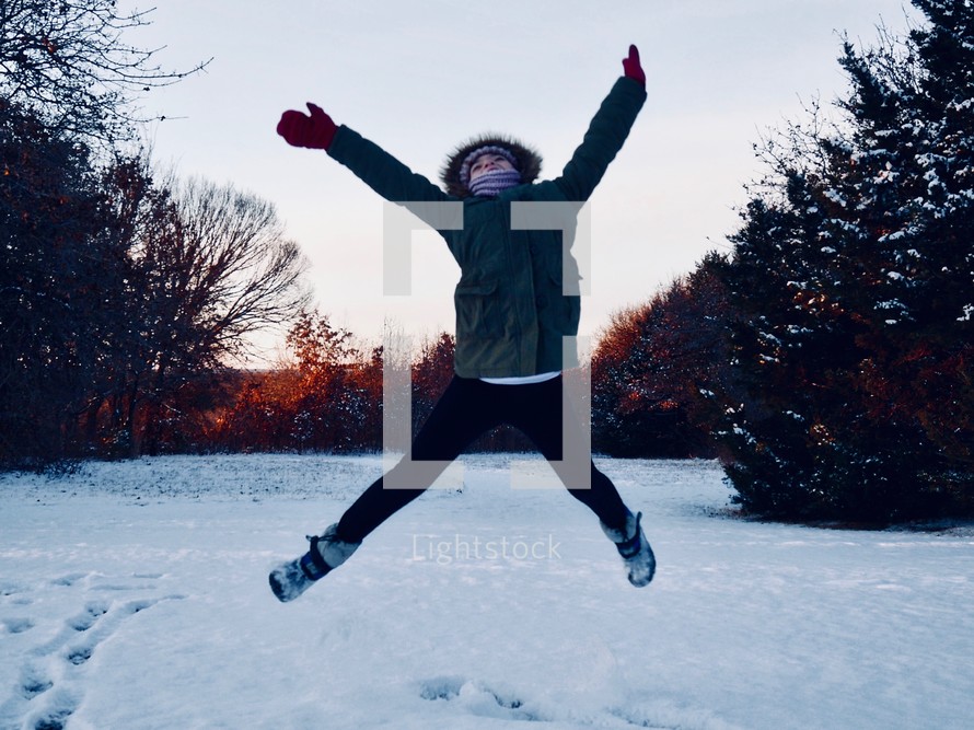 girl jumping in snow 