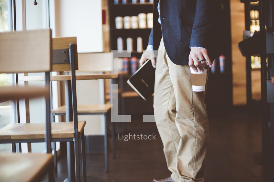 man carrying a Bible in a coffee shop 
