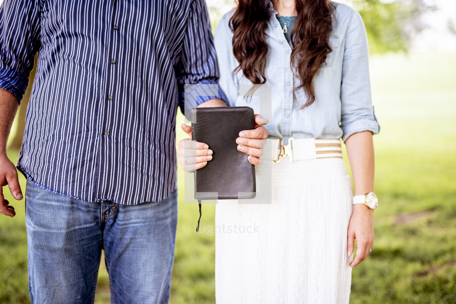 couple holding a Bible together 