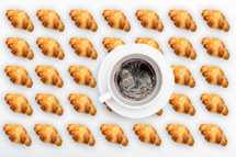 Pattern French croissant on a light background with cup of coffee