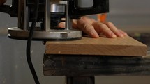 A woodworker shaping wood with a power tool