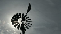 The sun shining through a traditional ranch windmill out west