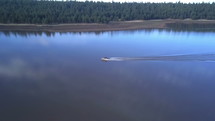 Aerial of a motor boat on a calm lake in the morning