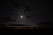 The moon, stars and glowing clouds at early dawn