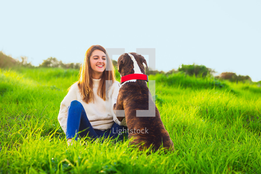 Young woman sitting and training dog