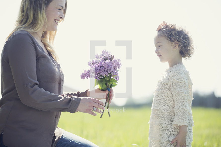 a little girl giving mom flowers 