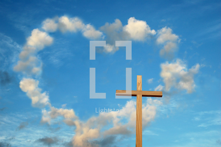 clouds in the shape of a heart in a blue sky and a wood cross