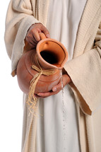 Man in biblical costume pouring water out of a clay pitcher