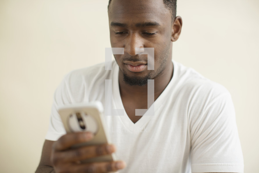 African American man texting on his phone.