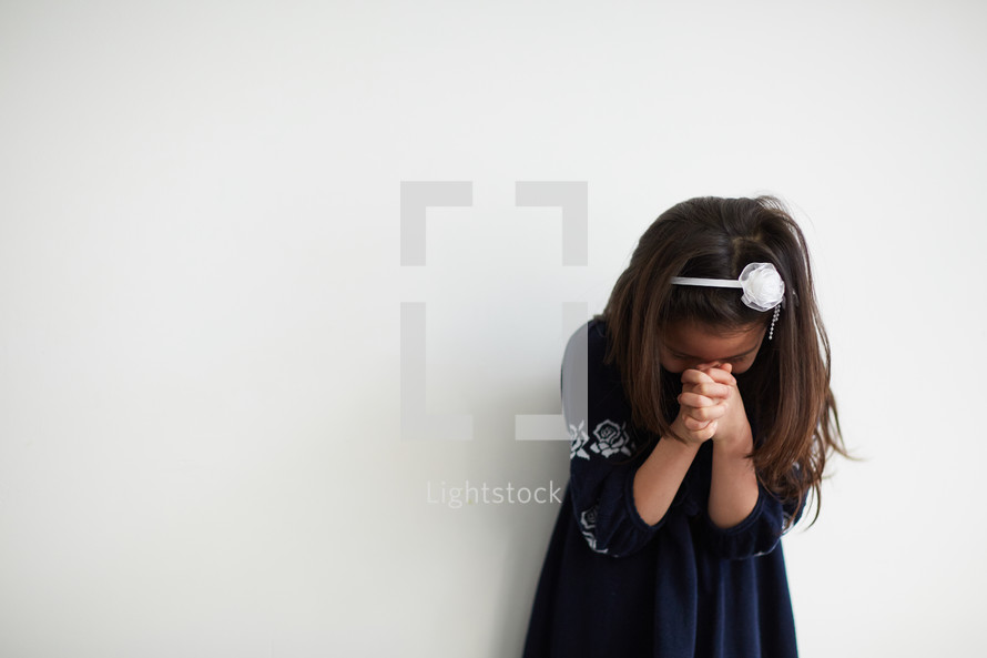 girl with head bowed in prayer