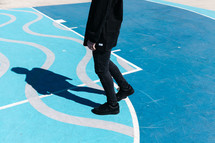 shadow of a man standing on blue painted concrete 
