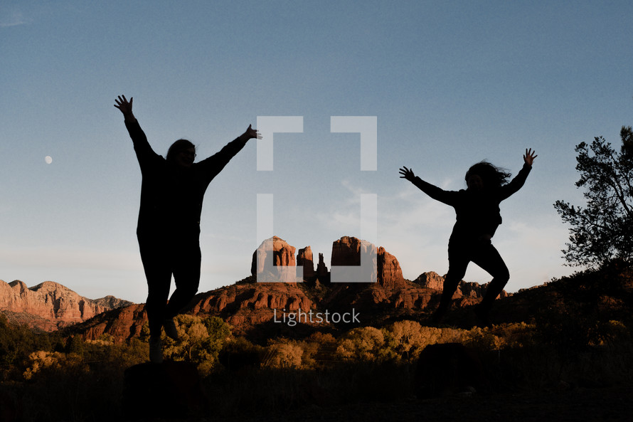 silhouettes jumping in a desert landscape 