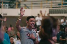 man with hand raised during a worship service 