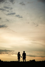 silhouette of a couple holding hands 