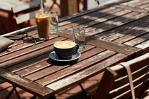 iced coffee and cappuccino on a wooden table outdoors 